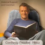 Man reading a book on a chair with a Corduroy Reading Pillow, text 'Balance Support and Comfort' and 'Corduroy Reading Pillow' displayed.